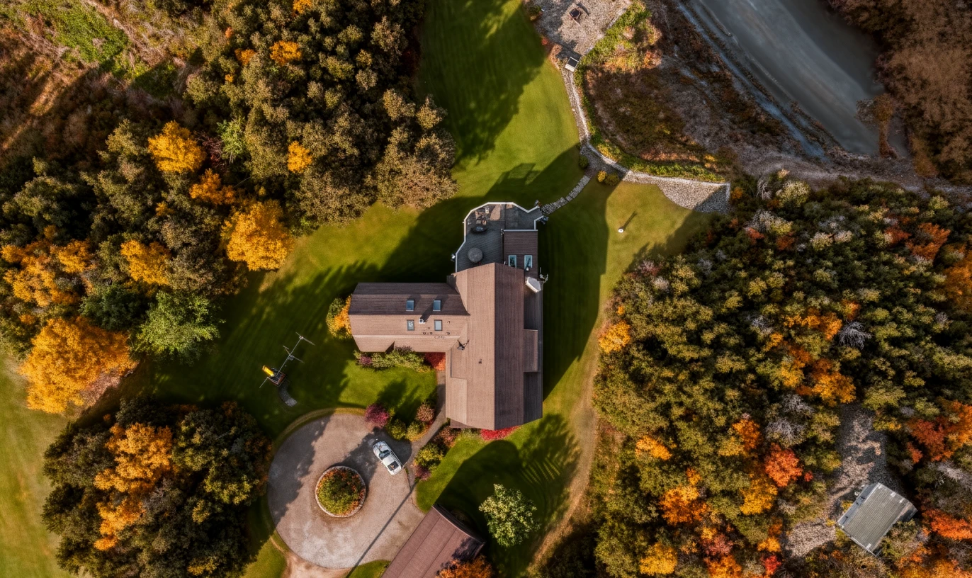 Drone-like property view showing building and surrounding land.