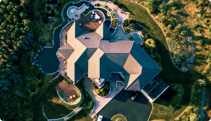 Drone-like property view showing estate roofline and surrounding access.