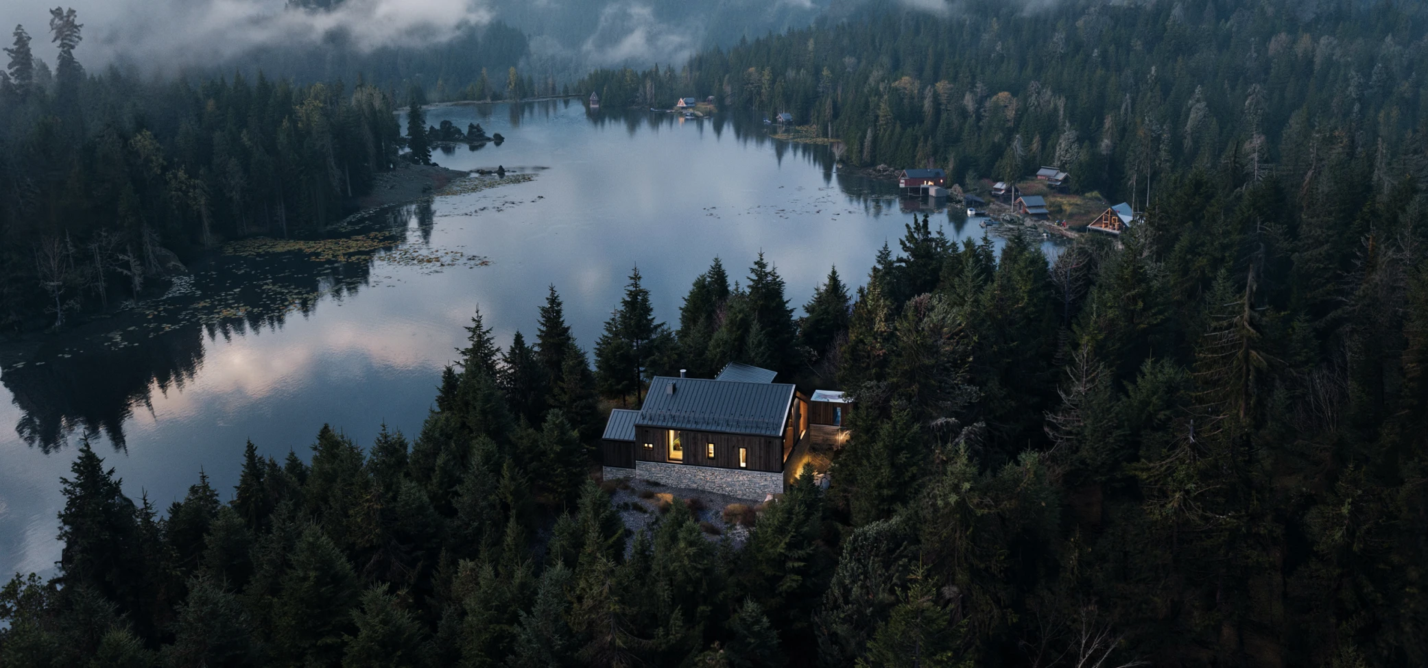 Composed property view showing a home beside a forest lake.
